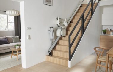 HomeGlide stairlift by ACCESS BDD demonstrating folding rail on a wooden staircase in a residential home.